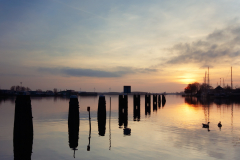 zonsondergang bij aanmeerpalen