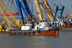 vrachtschip vaart bij werf met kranen